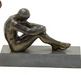 MID 20TH CENTURY BRONZE OF A SEATED PENSIVE MALE NUDE ON A BLACK METAL PLINTH BASE | Work of Man